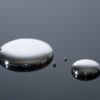 Droplets of mercury on a reflective surface.