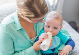 Mother feeding milk to a hungry toddler